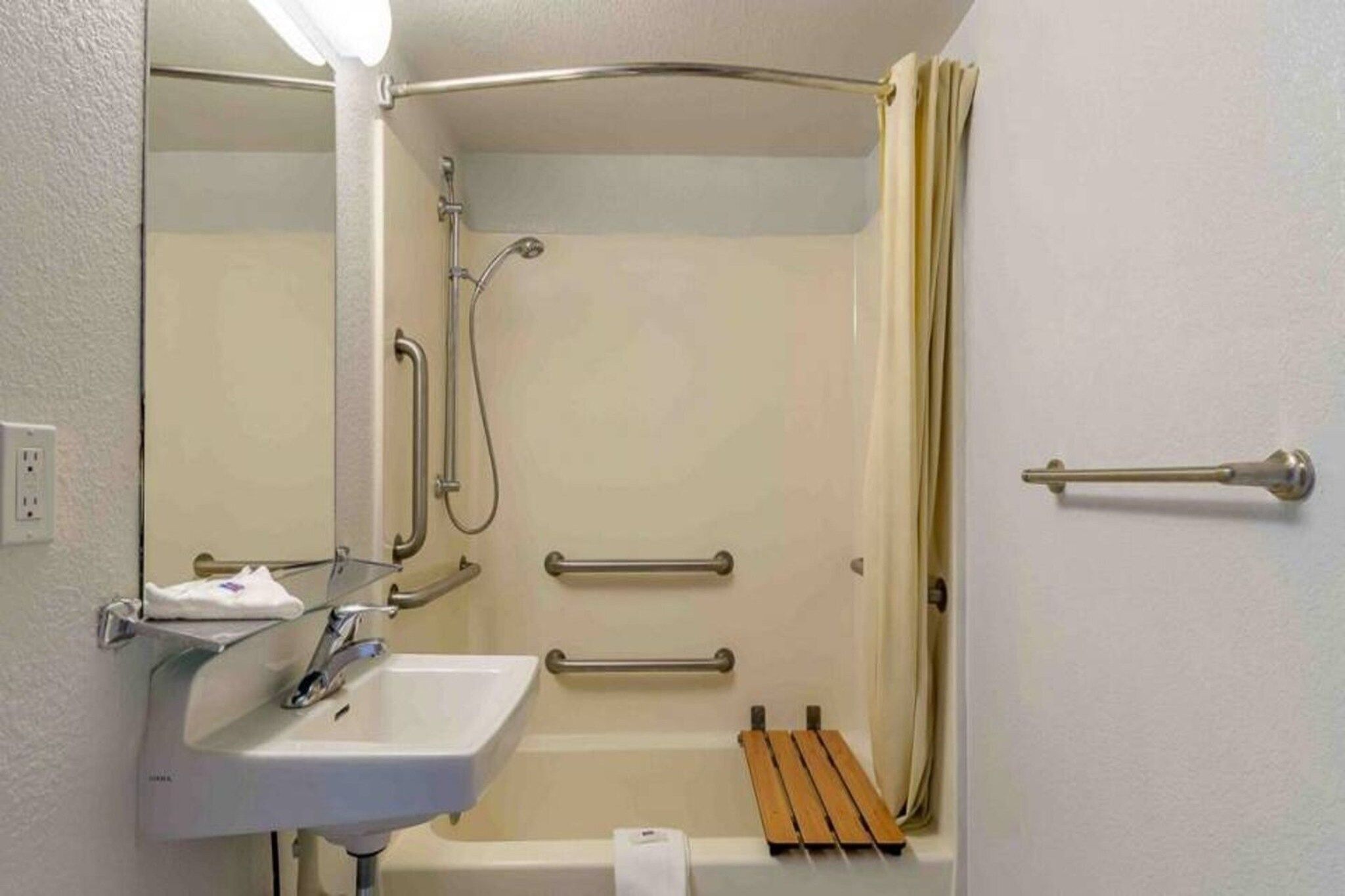 A bathroom with a shower, a sink, and a toilet.
