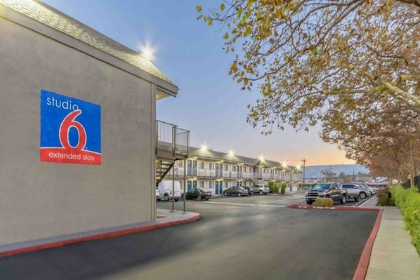 A hotel named Studio 6 with extended stay rooms, a parking area, and a view of the street. - 1 Full Bed | Smoking, Kitchen (Hayward)