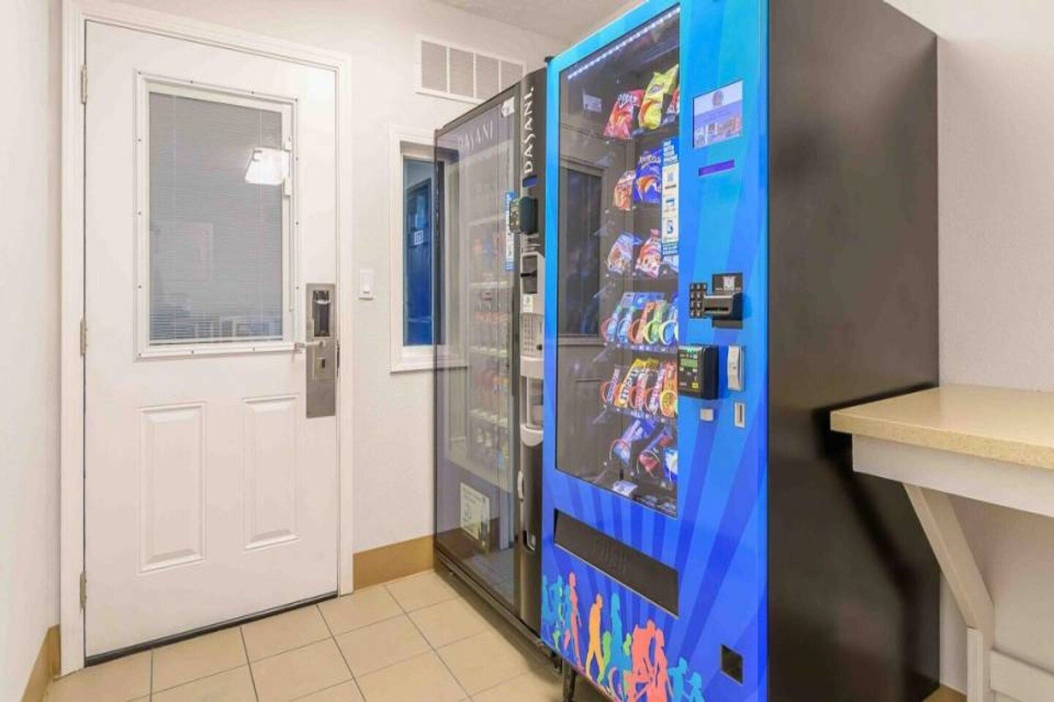 Ein Getränkeautomat mit Snacks und eine Tür mit Fenster.