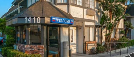 A building with a 'WELCOME' sign and the number '1410' above the entrance.