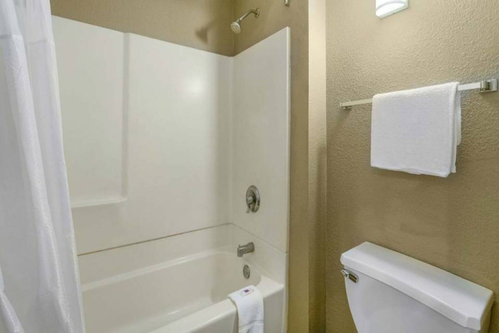 Un bagno con una vasca, un water e una tenda da doccia.