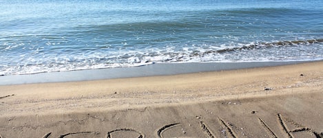 A beach with the word 'VERSILIA' written in the sand.