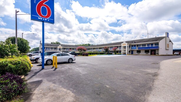 Un motel con un letrero que indica WiFi gratuito, un estacionamiento y un edificio con varias unidades.