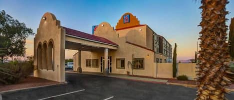 A hotel with a distinctive architectural style, featuring arched entryways and a flat roof.