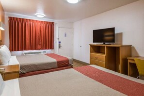 Una habitación de hotel con dos camas, televisión, escritorio y silla.
