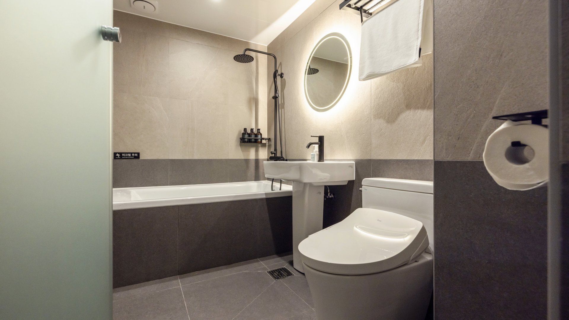 A modern bathroom with a bathtub, toilet, and sink.