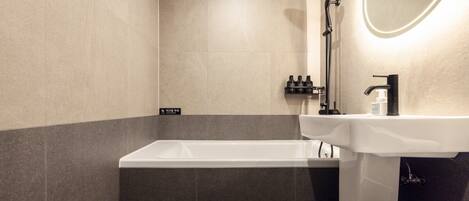 Un baño moderno con bañera, lavabo y ducha.