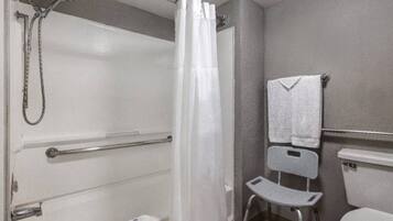 A bathroom with a shower, a toilet, and a grab bar.