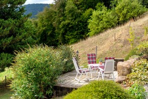 Un patio con mobiliario exterior y vistas a un paisaje selvático.