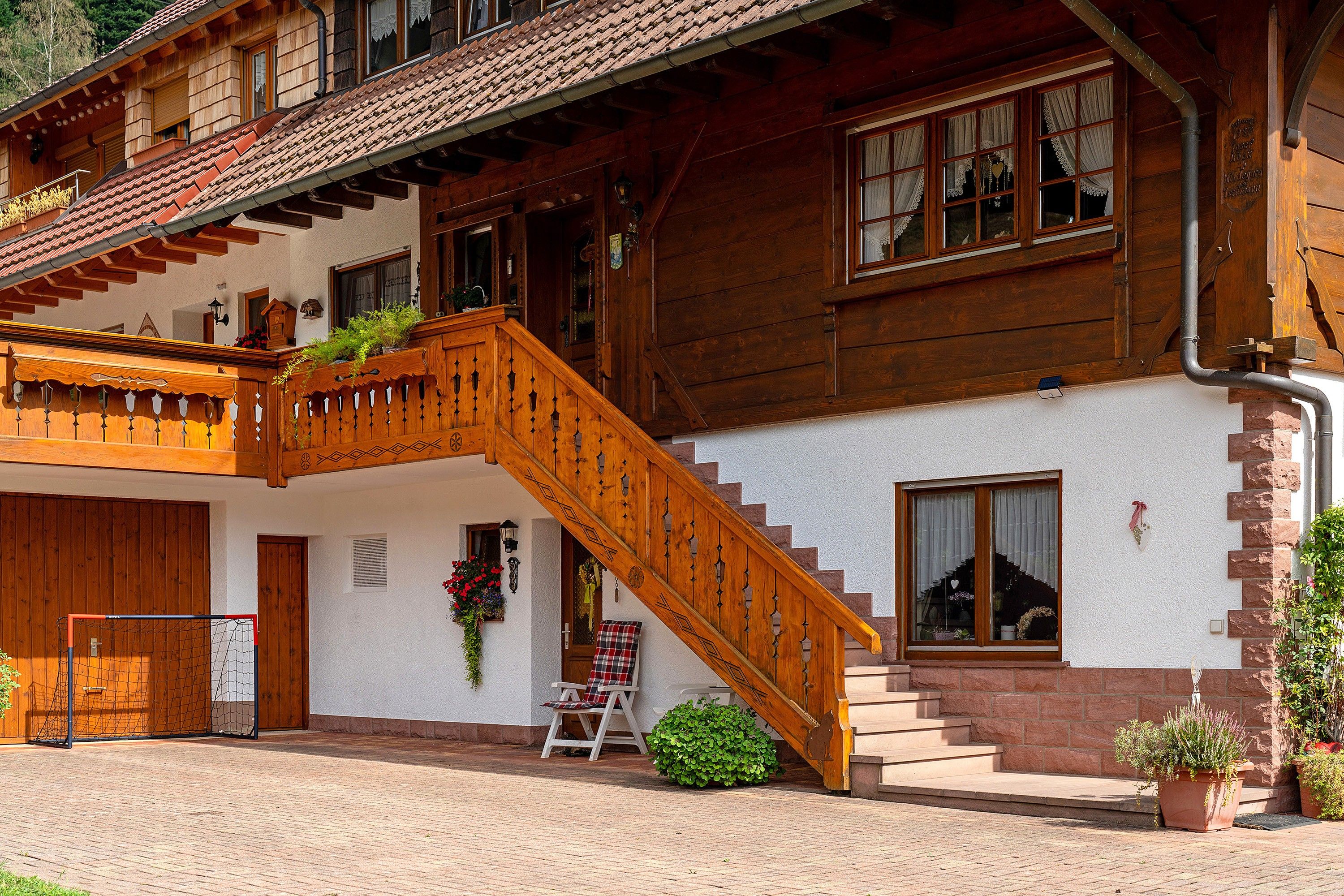 A traditional wooden house with a wooden staircase leading to the entrance.