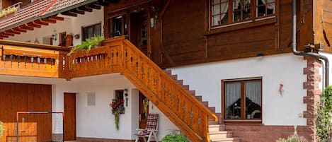 Ein traditionelles Holzhaus mit einer Holztreppe, die zum Eingang führt.