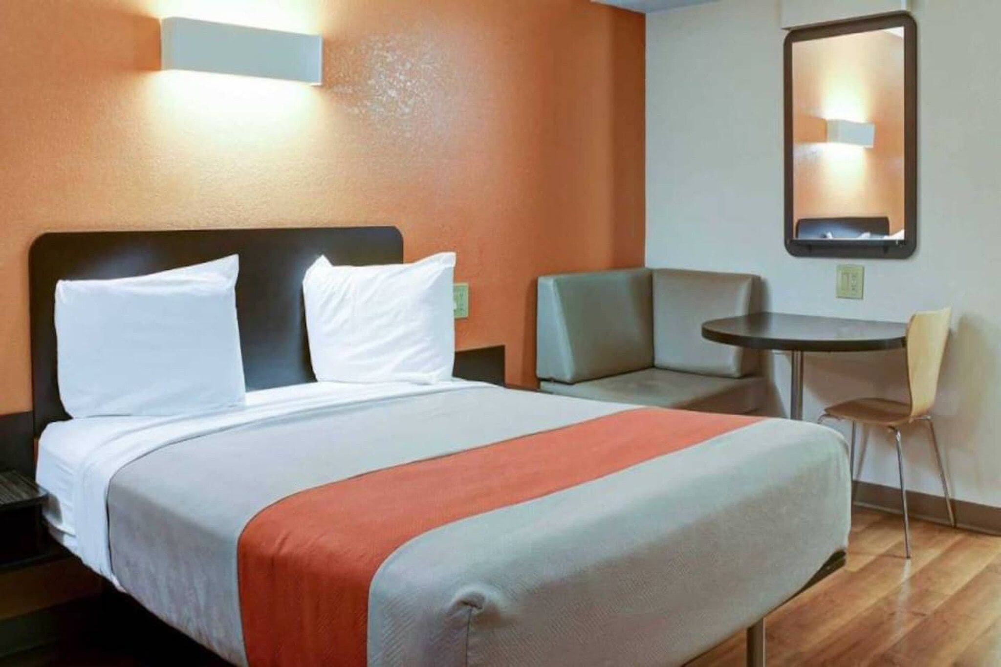 Ein Hotelzimmer mit Bett, Schreibtisch, Stuhl und kleinem Tisch.