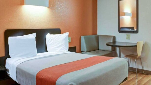 Ein Hotelzimmer mit Bett, Schreibtisch, Stuhl und kleinem Tisch.
