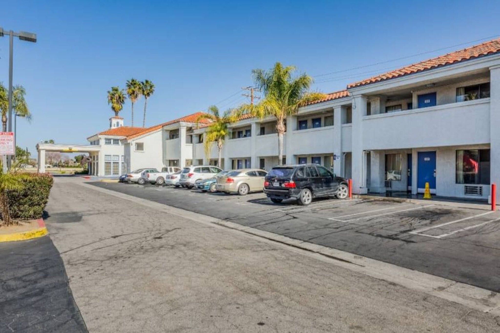 A row of single-story buildings with a parking lot in front.