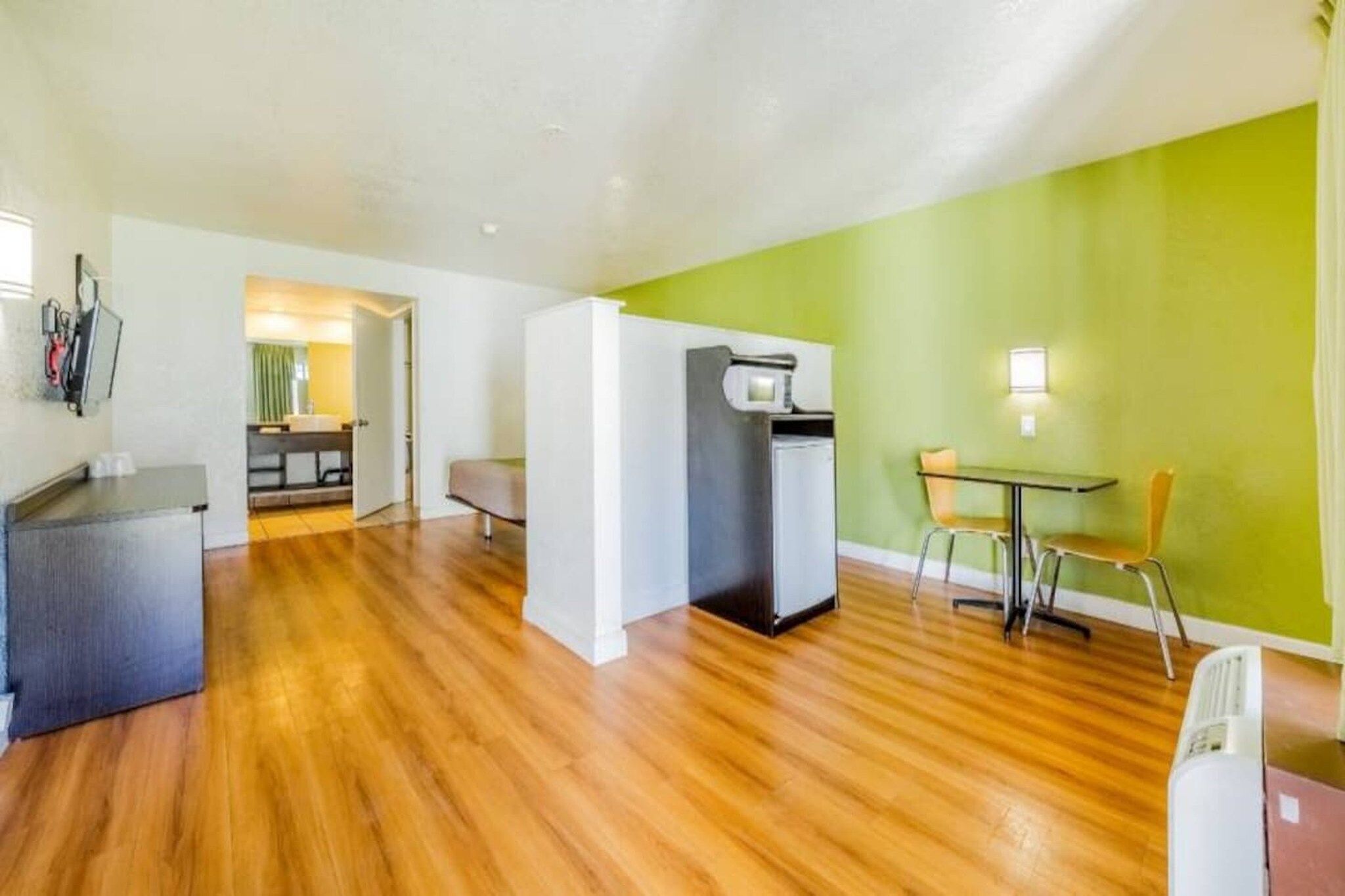 A compact living space with a kitchenette, a dining area, and a separate bathroom.