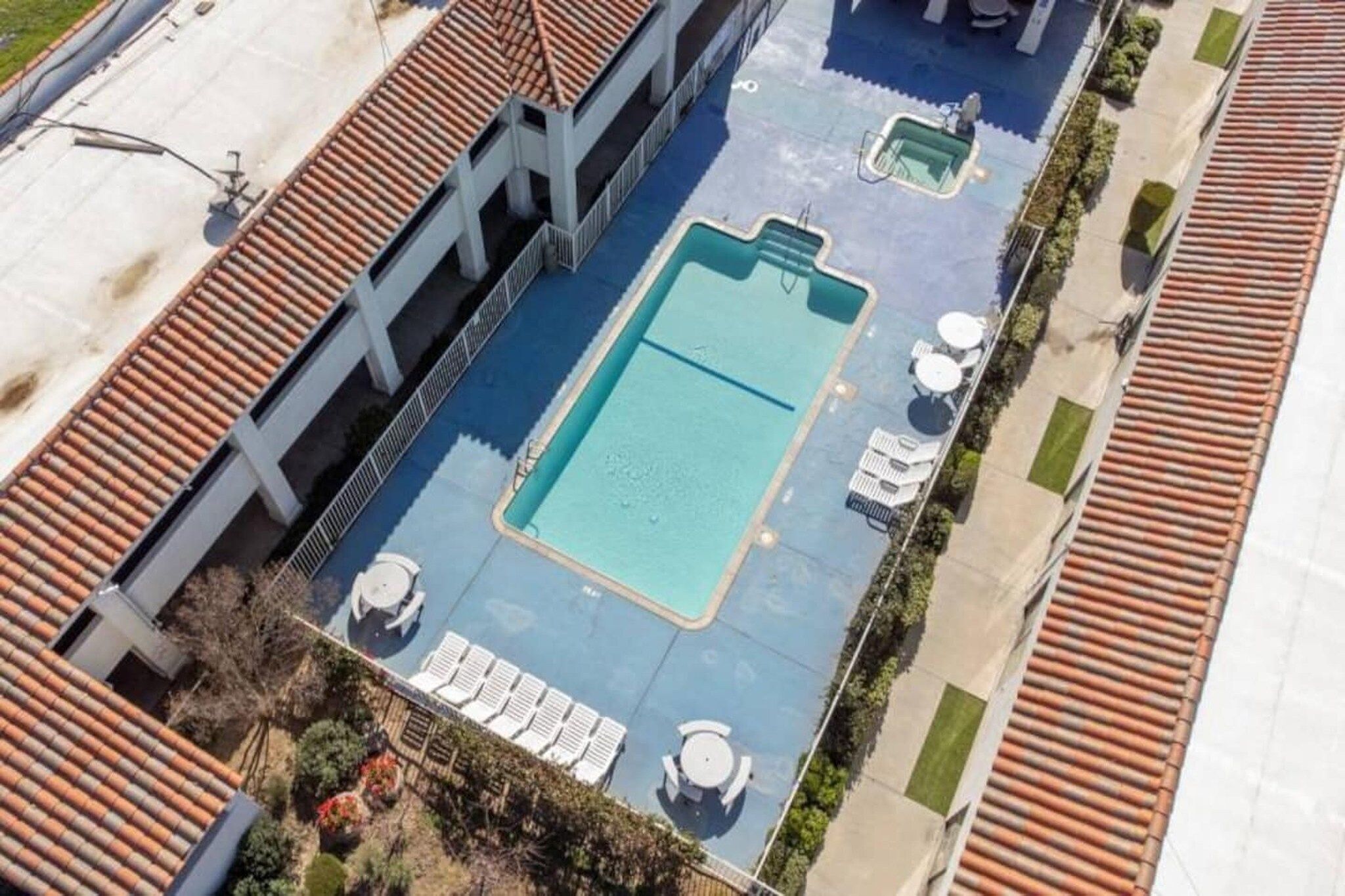 Ein Pool auf dem Dach mit Liegestühlen und einem kleinen Tisch.