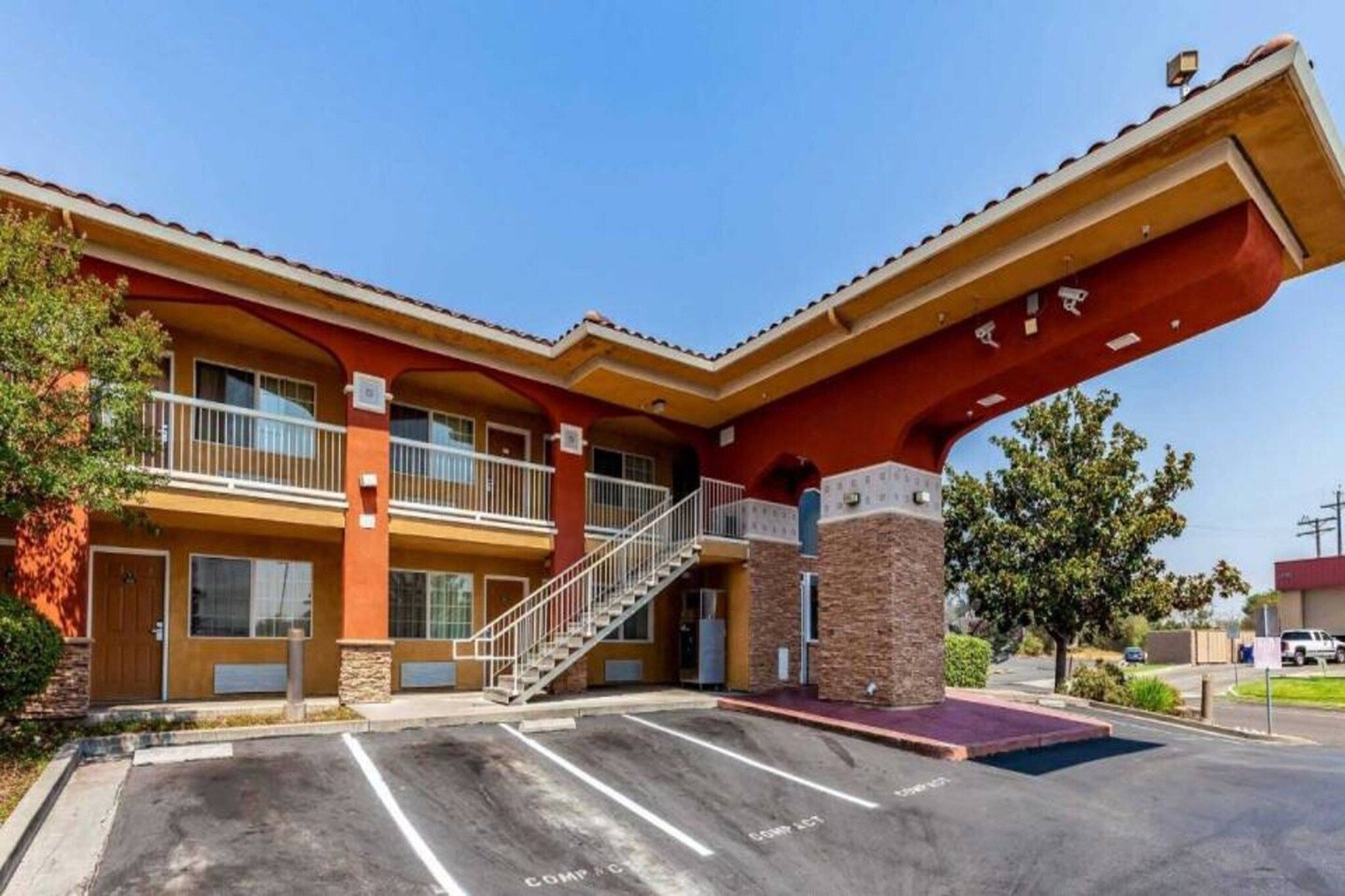 A two-story building with a covered entrance and a staircase leading to the upper level.