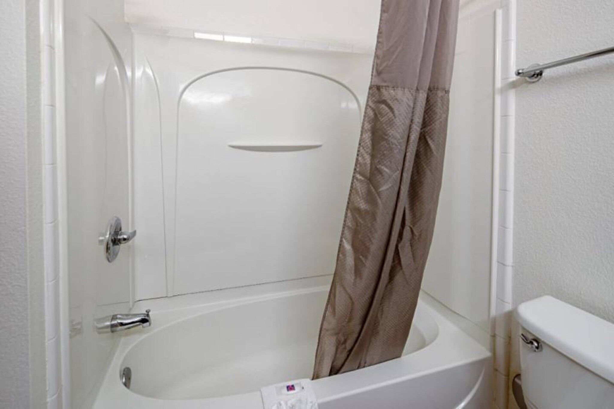 Un baño con bañera, inodoro y cortina de ducha.