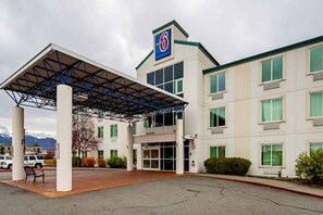 Un motel con entrada cubierta, varias ventanas y un letrero que indica el nombre.