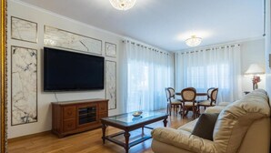 Ein Wohnzimmer mit Flachbildfernseher, Holzmöbeln und Marmorbildkunst.