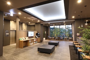 A modern lobby with a reception desk, seating area, and a large window offering a view of the outdoors. - HotelRouteInnKobesanda-ShinSandaEkimae- (Sanda)