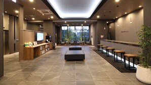 A modern lobby with a reception desk, seating area, and large windows. - HotelRouteInnKobesanda-ShinSandaEkimae- (Sanda)