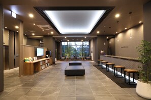 A modern lobby with a reception desk, seating area, and large windows. - HotelRouteInnKobesanda-ShinSandaEkimae- (Sanda)