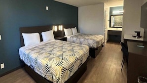 Ett hotellrum med två sängar, ett skrivbord och en stol.