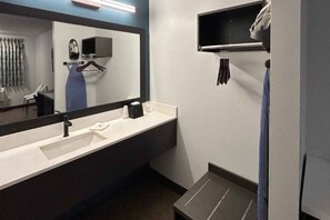 Une salle de bain moderne avec un grand miroir, un lavabo et un porte-serviettes.