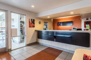 A reception area with a glass door entrance, a clock, and a counter with a number sign. - Spacious 2-Bed Room|Vending machine (El Centro)