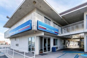 A building with a 'WELCOME' sign, a covered entrance, and a ramp leading to the entrance.