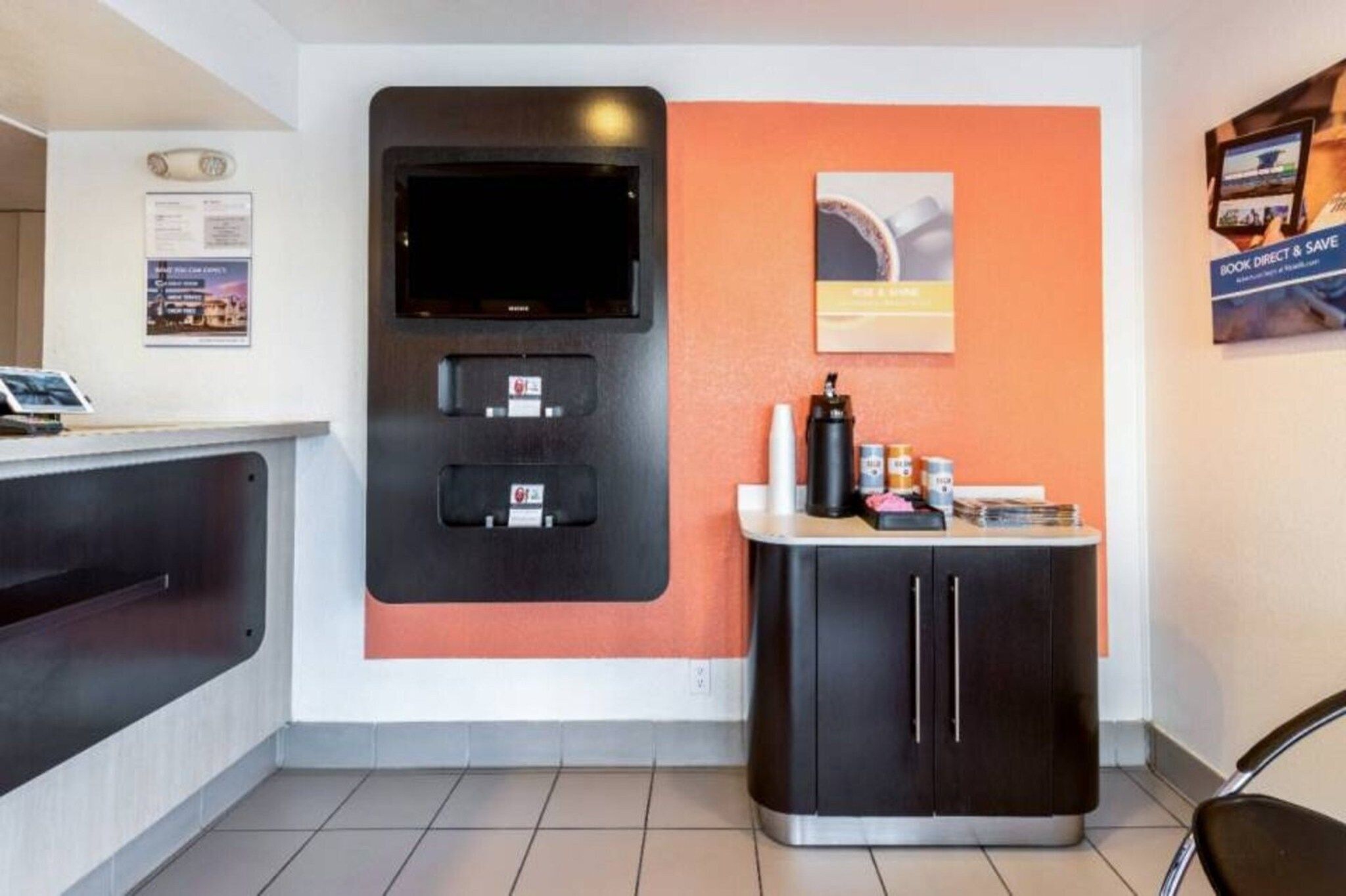 Ein Empfangsbereich mit Flachbildfernseher, Selbstbedienungskiosk und Kaffeeautomat.
