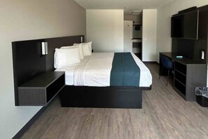 Une chambre d’hôtel moderne dotée d’un grand lit, de sièges intégrés, d’un bureau et d’une télévision.