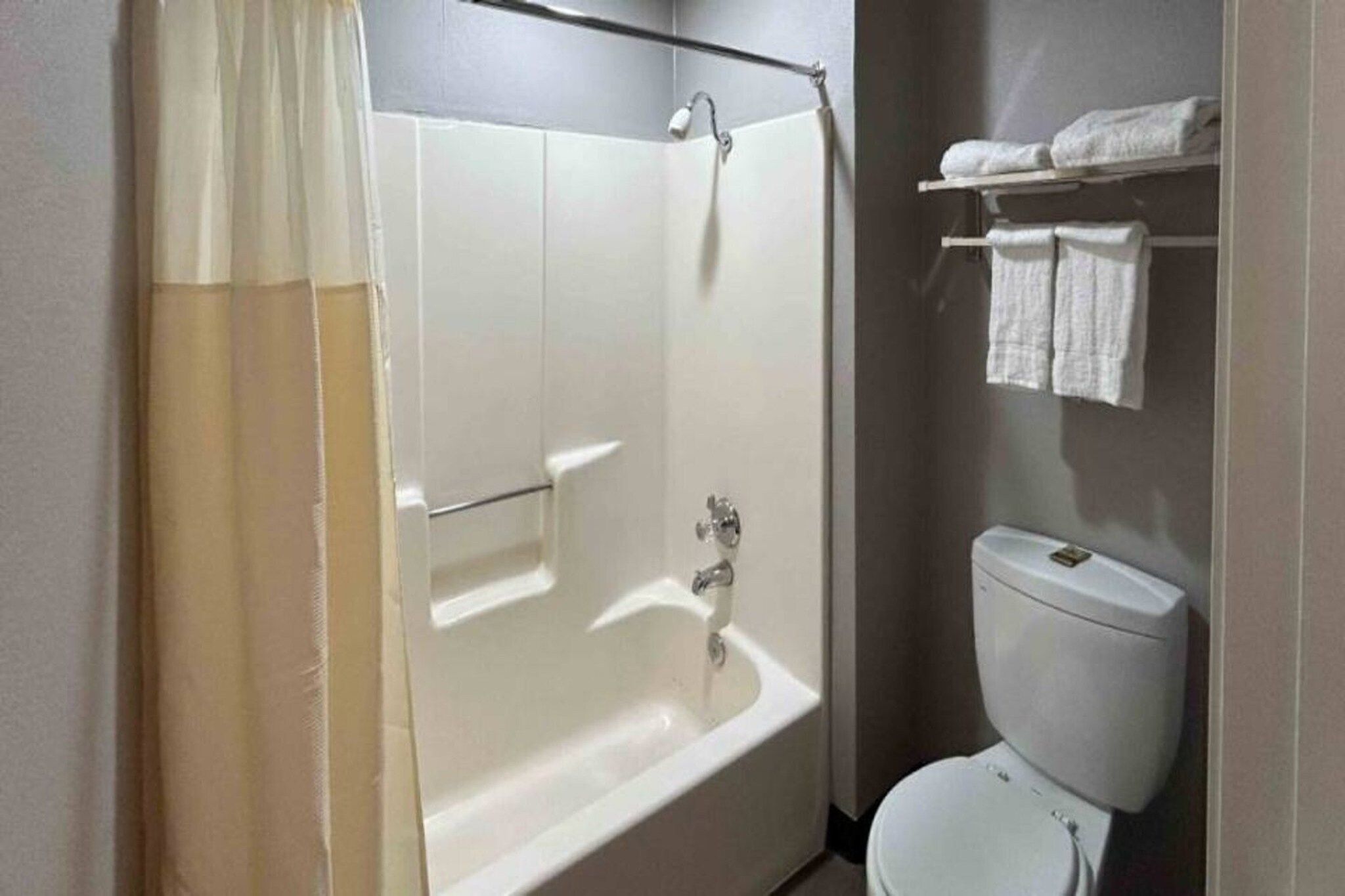 Un baño con bañera, inodoro y toallero.