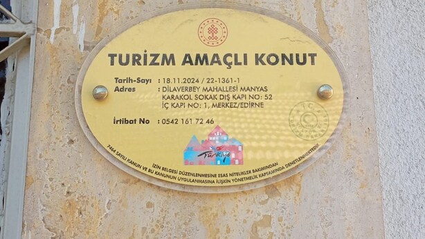 Ein Schild mit dem Aufdruck 'TURIZM AMAÇLI KONUT', das eine Unterkunft für Touristen kennzeichnet.