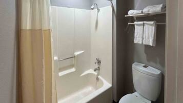 Un baño con bañera, inodoro y toallero.