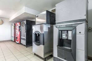A row of vending machines, including a Coca-Cola cooler and an ice dispenser.