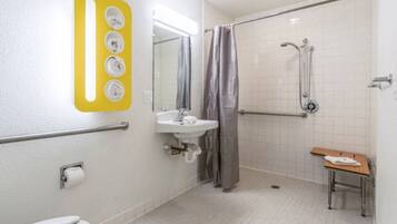 Un baño con ducha, lavabo, inodoro y un banco.