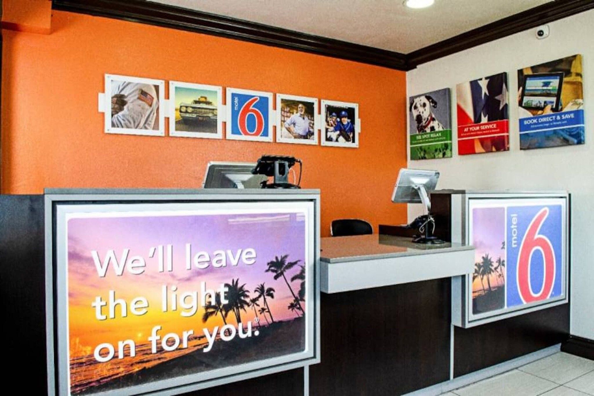 Een hotel receptiebalie met een groot bord waarop staat: 'Wij laten het licht voor u aan'.