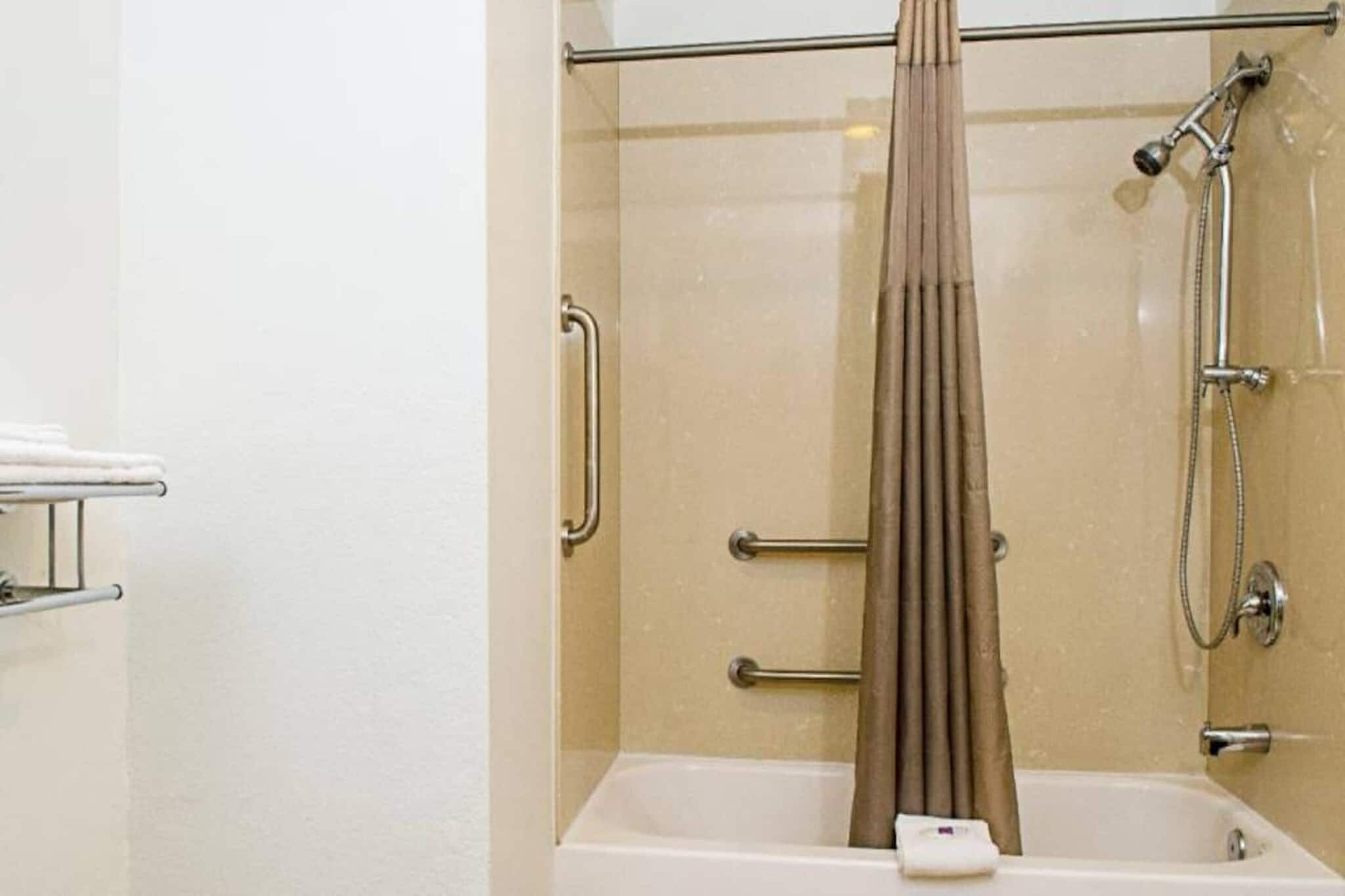 A bathroom with a bathtub, a shower, and a curtain.