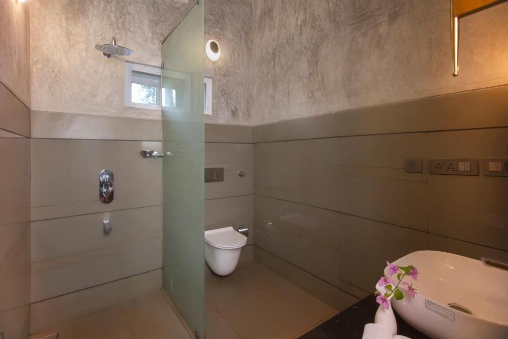 Un baño moderno con cabina de ducha de vidrio, inodoro y bañera.