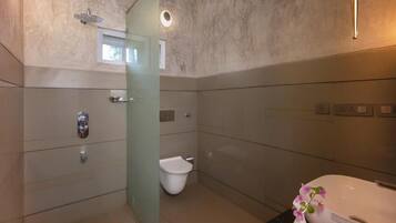 Un baño moderno con cabina de ducha de vidrio, inodoro y bañera.