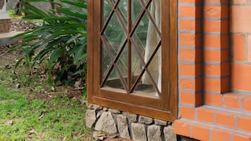 A window with a diamond pattern, a brick wall, and a stone base.