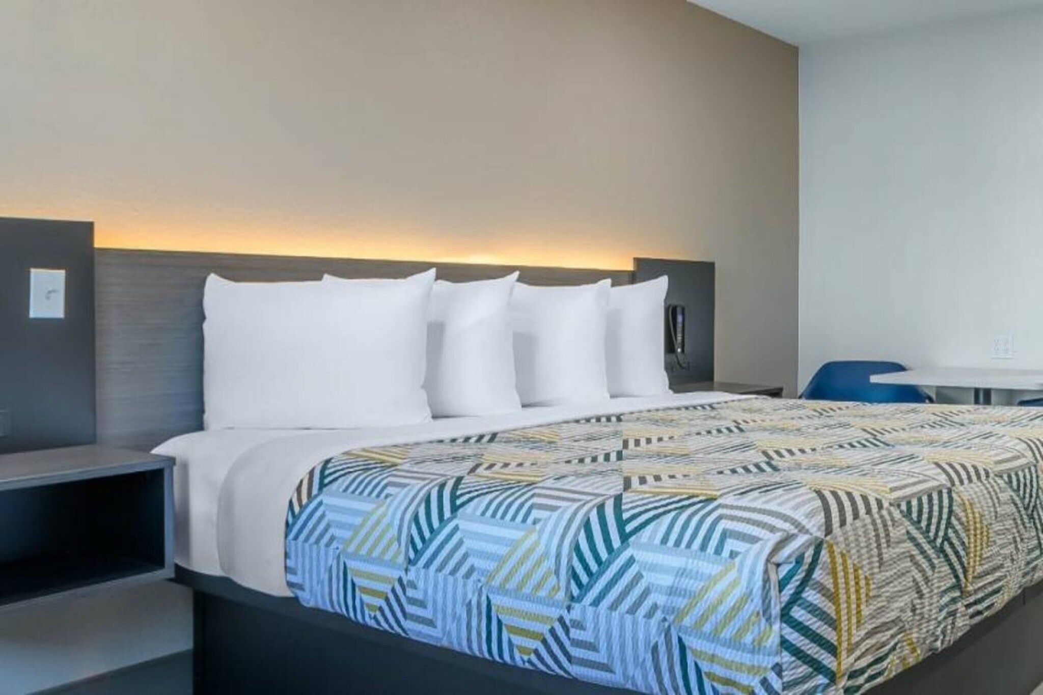 A hotel room with a bed, a desk, and a chair.