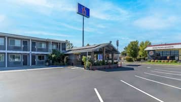 A parking lot with a building featuring a blue sign with the number 6.