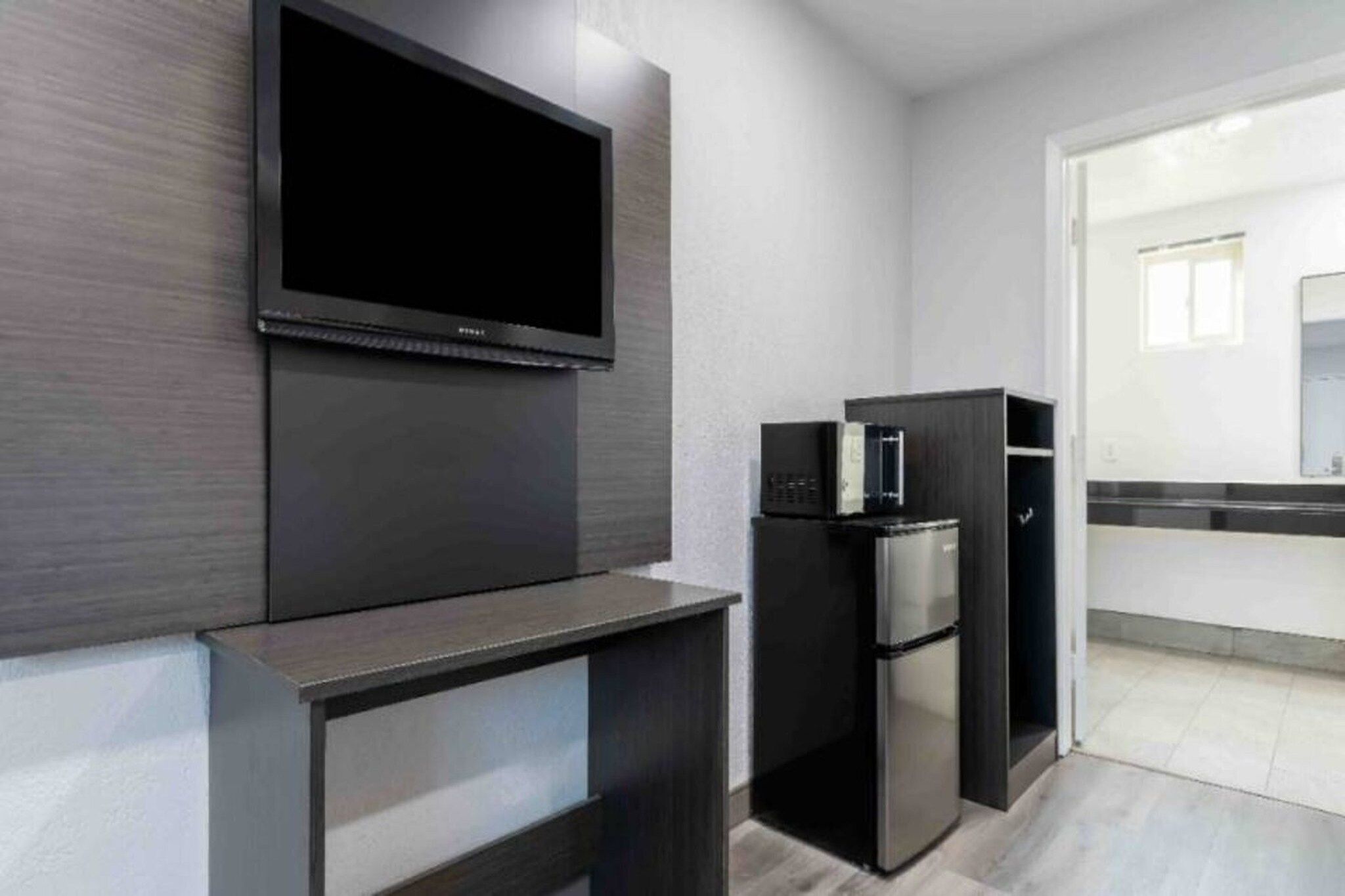 Eine moderne Küche mit integriertem Fernseher, einem Kühlschrank und einer Mikrowelle.