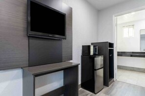 A modern kitchen with a built-in TV, a refrigerator, and a microwave.