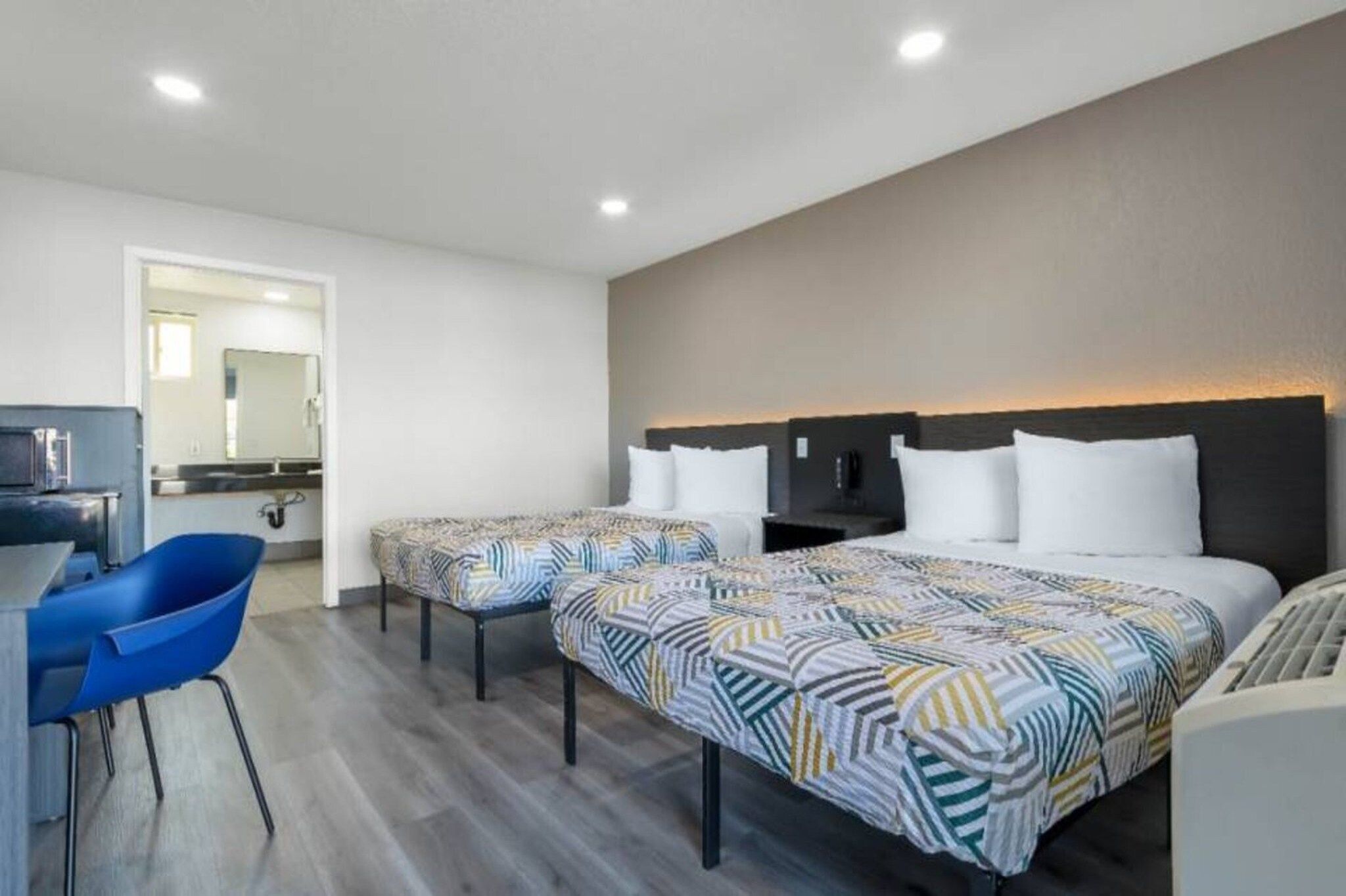 Una habitación de hotel con dos camas, un escritorio y una silla.