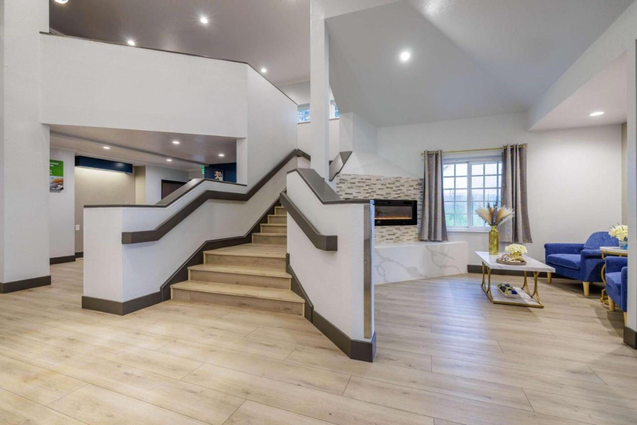 Un interior moderno con una escalera, una chimenea y un área de descanso.