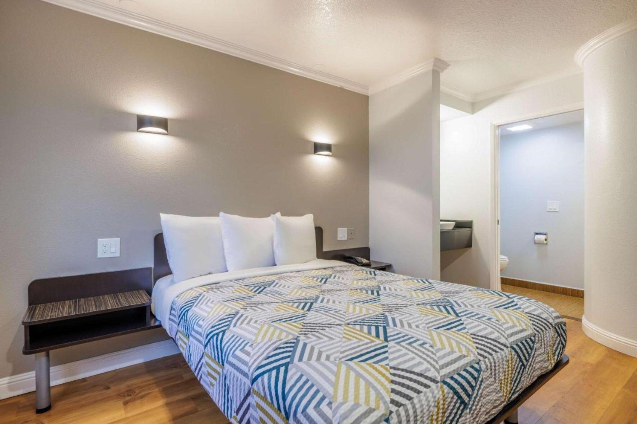 A bedroom with a bed, bedside tables, and a nightstand.